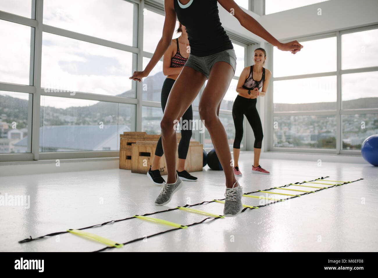 Donna formazione sulla scaletta di agilità in palestra. Lezione di fitness  cardio allenamento con la scaletta di velocità n. piano Foto stock - Alamy
