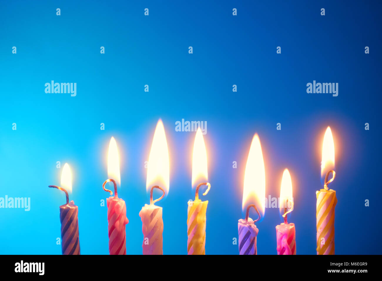 Holiday - compleanno candele in una riga su sfondo blu Foto Stock