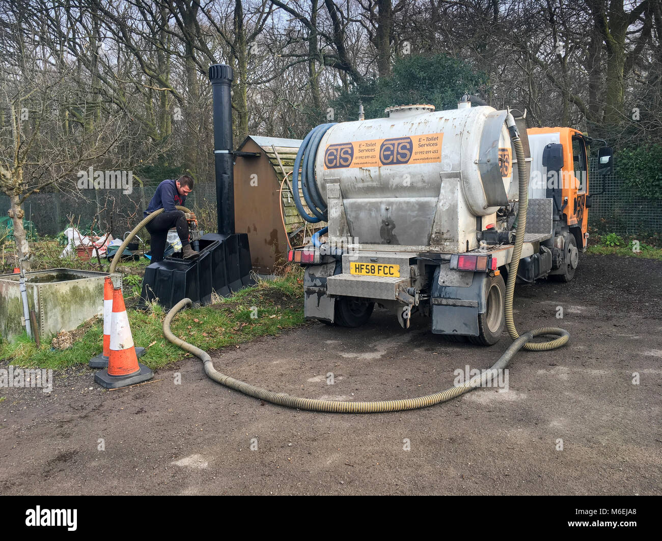 Un tecnico di servizio dal compostaggio wc società di manutenzione pompe ETS fuori un waterless wc a East Finchley assegnazioni. Foto Stock