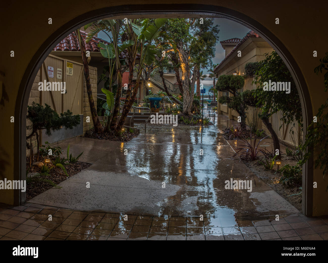 Arco in Ventura Harbour Village mostra alberi riflessa sul marciapiede a causa di mattina presto la tempesta di pioggia il 3 marzo 2018 in California, Stati Uniti. Foto Stock