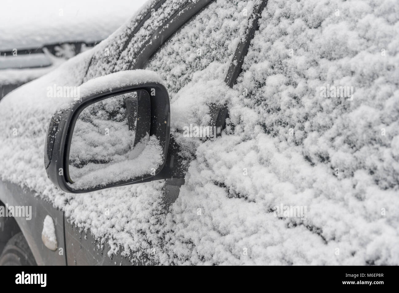 Coperta di neve specchietto laterale durante il 2018 Bestia da est vortice polare condizioni della neve che ha causato problemi molto diffuso per pendolari e viaggi. Foto Stock