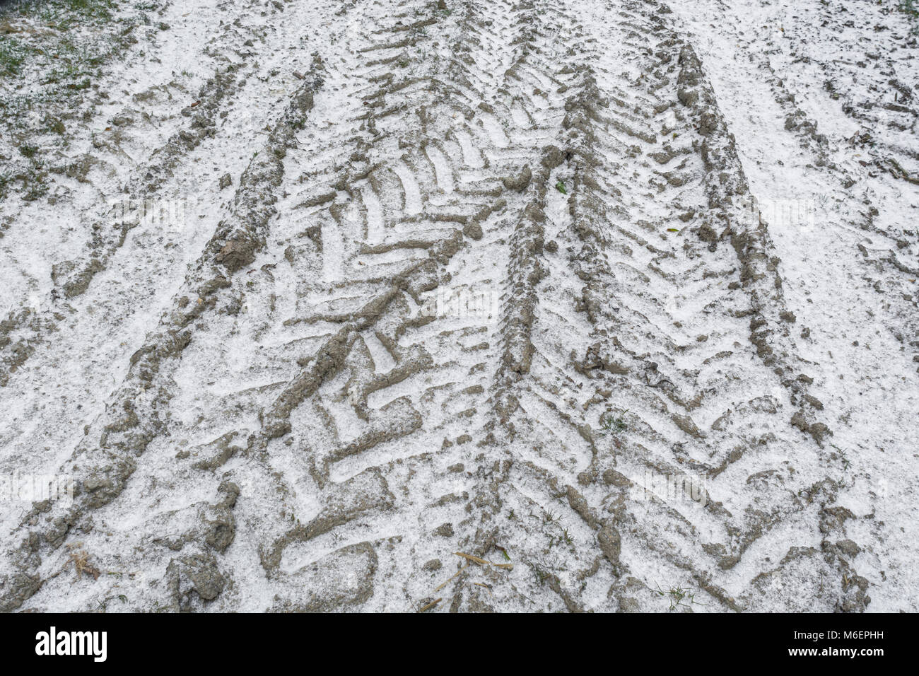 Coperta di neve il pneumatico del trattore le vie durante la 'bestia da est' - potenziale per distruggere ed agricola. Foto Stock