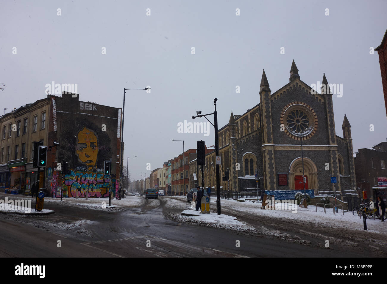 Vista di City Road Baptist Church, Bristol, accanto a una parete murale, nella neve durante la tempesta Emma Foto Stock