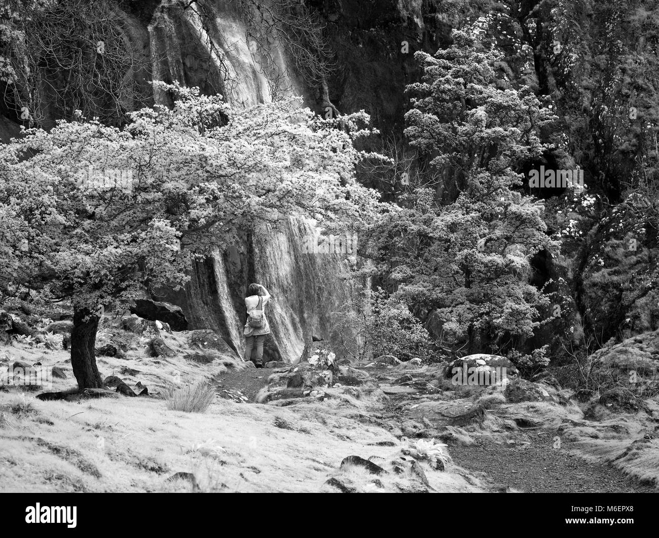 Fotografo presso Aber cade nel nord Snowdonia montagne visto dal Galles del Nord litorale vicino a Manchester Foto Stock