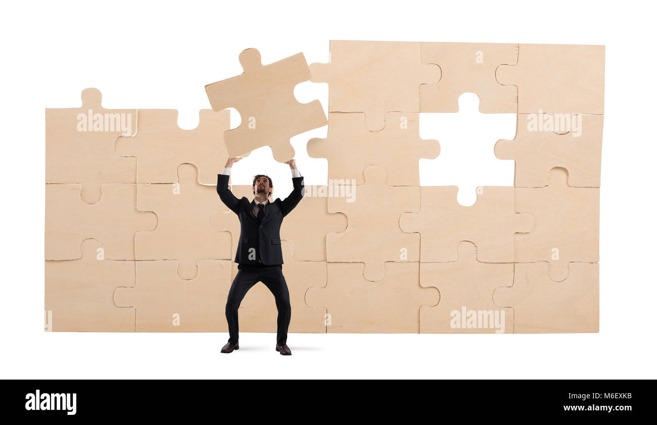 Imprenditore con un pezzo del puzzle. Costruire il concetto di business Foto Stock