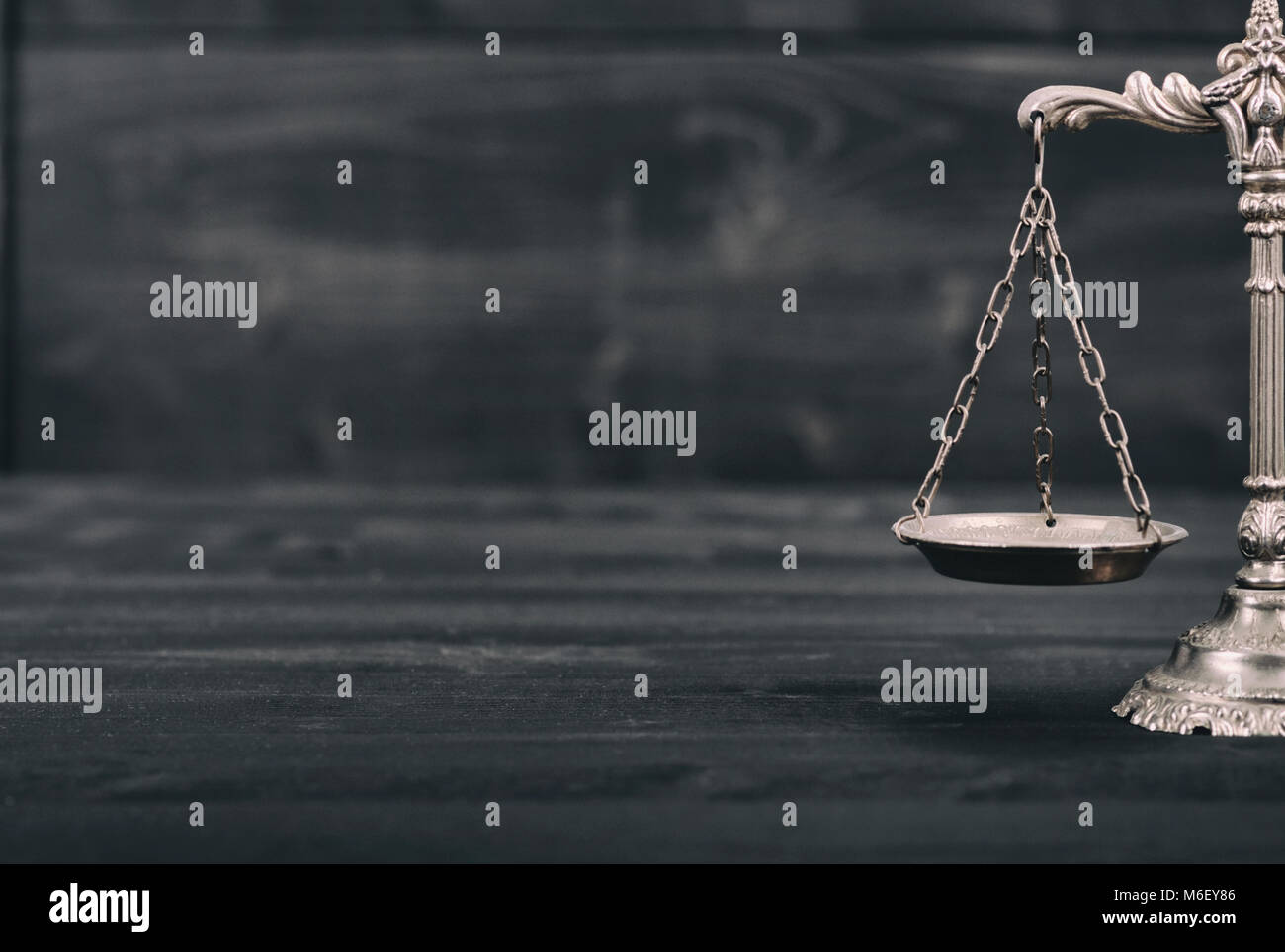 Il diritto e la giustizia, il concetto di legalità, bilancia della giustizia su un nero lo sfondo di legno. Foto Stock