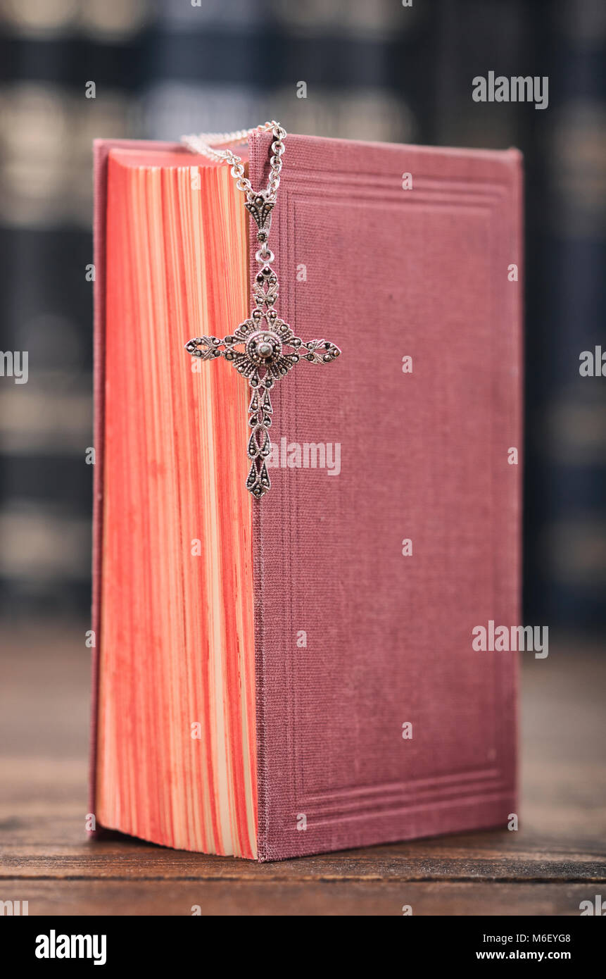 Una croce cristiana collana su una Sacra Bibbia, il cristianesimo e la religione del concetto. Foto Stock