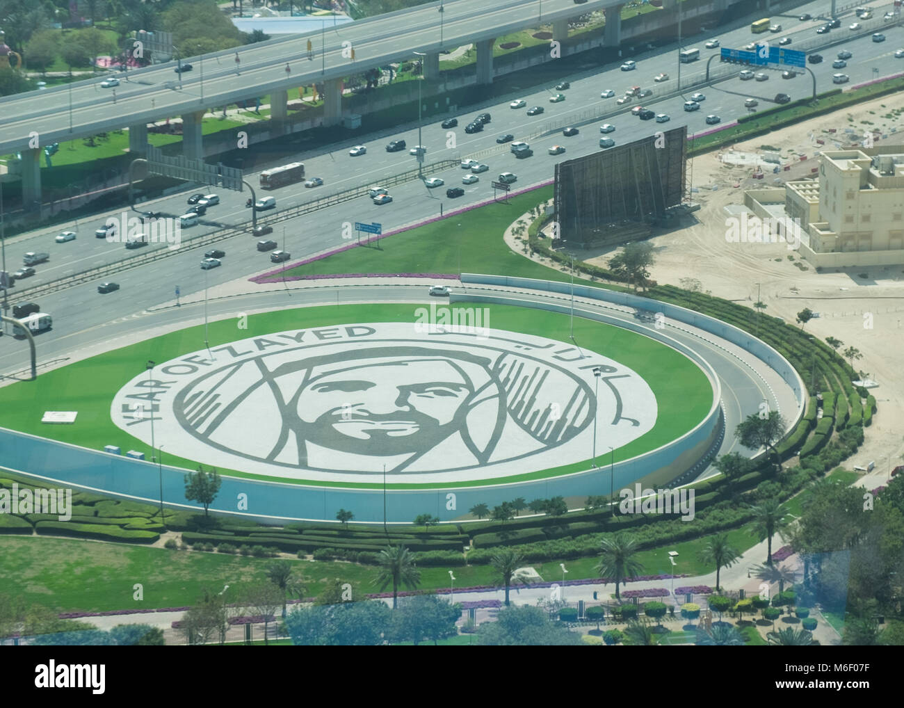 Segno distintivo di Dubai il telaio, guardando verso il basso in corrispondenza di un gigante Zayed ritratto accanto alla strada. Foto Stock