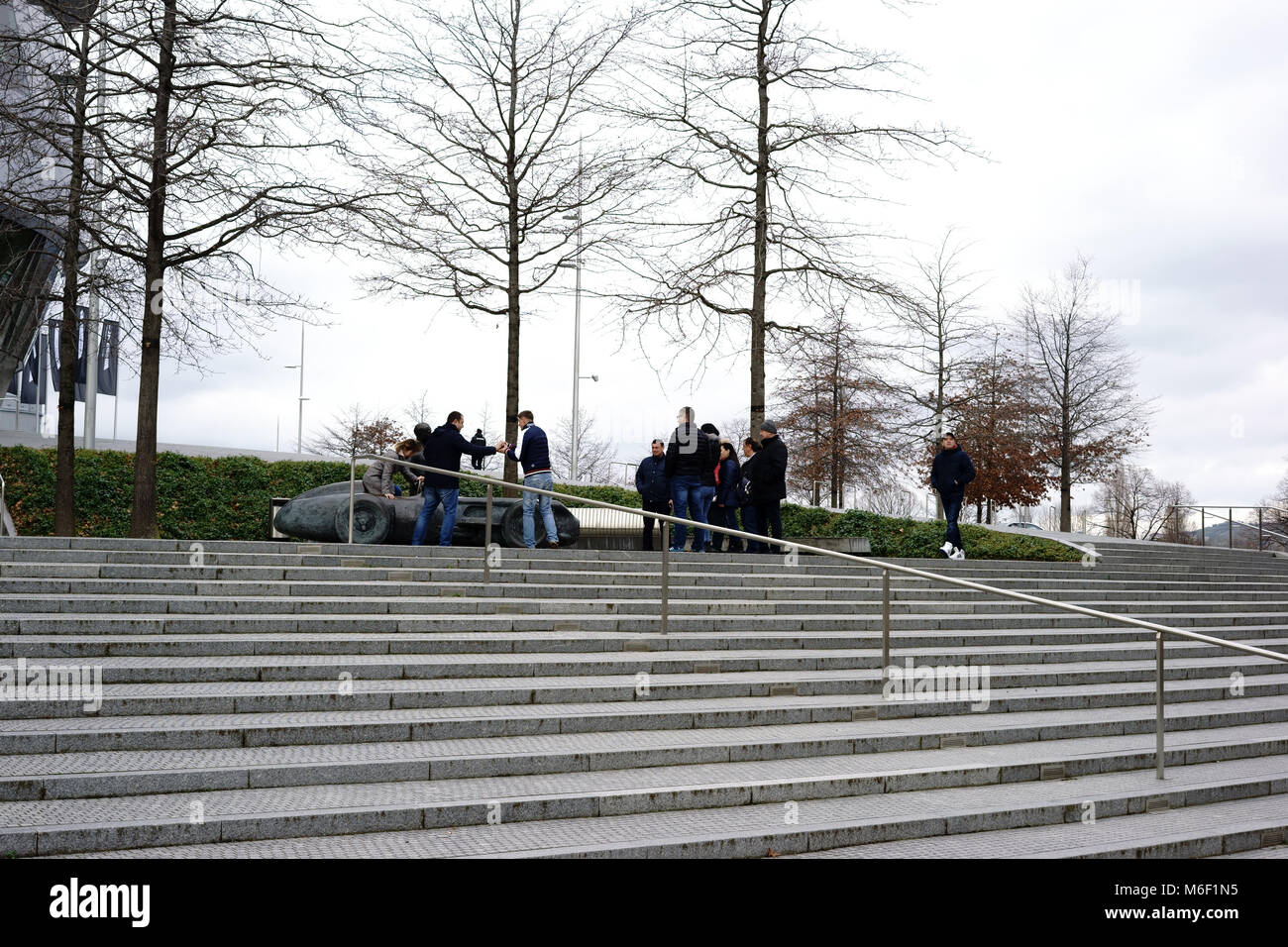 Stoccarda, Germania - Febbraio 03, 2018: turisti stand presso la scultura di una gara di auto di fronte all'ingresso del moderno museo Mercedes Benz su F Foto Stock