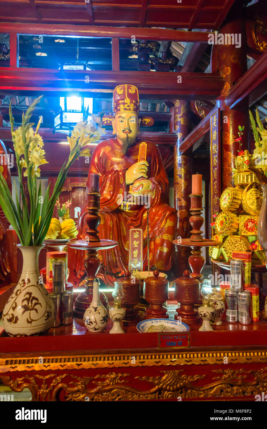 Altare laden con doni di cibo, fiori e denaro presso il Tempio della Letteratura ad Hanoi, Vietnam Foto Stock