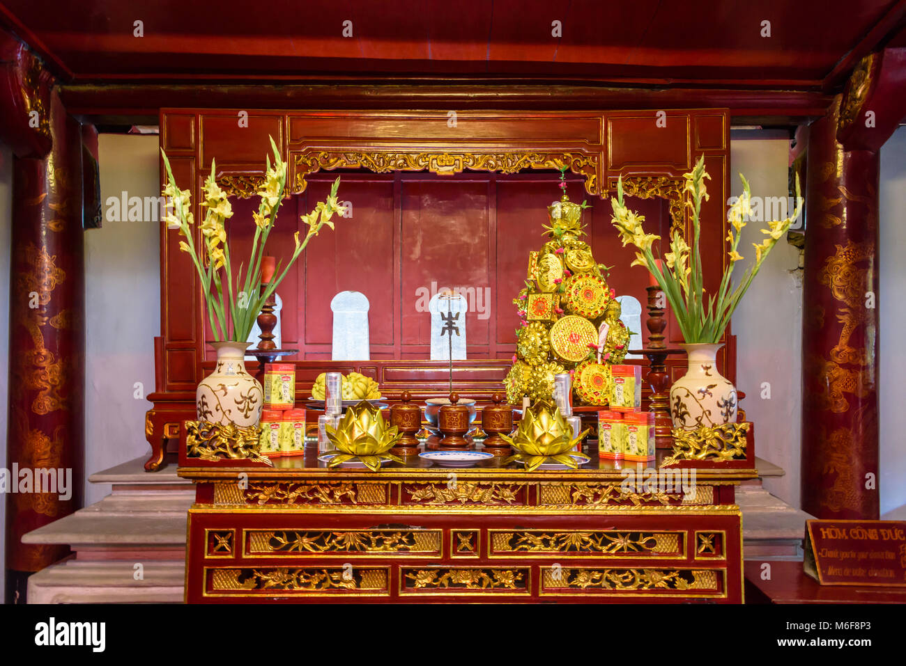Altare laden con doni di cibo, fiori e denaro presso il Tempio della Letteratura ad Hanoi, Vietnam Foto Stock