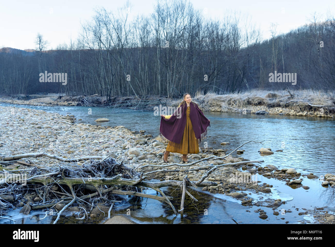Modello in posa contro lo sfondo di un fiume di montagna Foto Stock