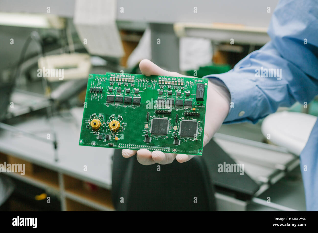 Tecnico di computer con scheda a circuito stampato con chip. I pezzi di ricambio e componenti per apparecchiature informatiche. Produzione di elettronica e di manutenzione. Foto Stock