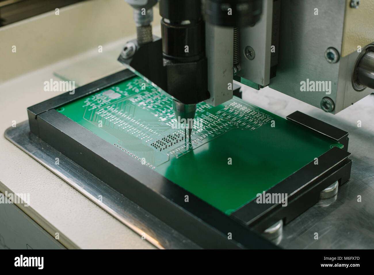 Automazione della macchina di assemblaggio del circuito integrato del computer in fabbrica per la produzione di componenti di un computer. Il processo di saldatura del bordo. La fabbrica per la produzione di microchip. Foto Stock