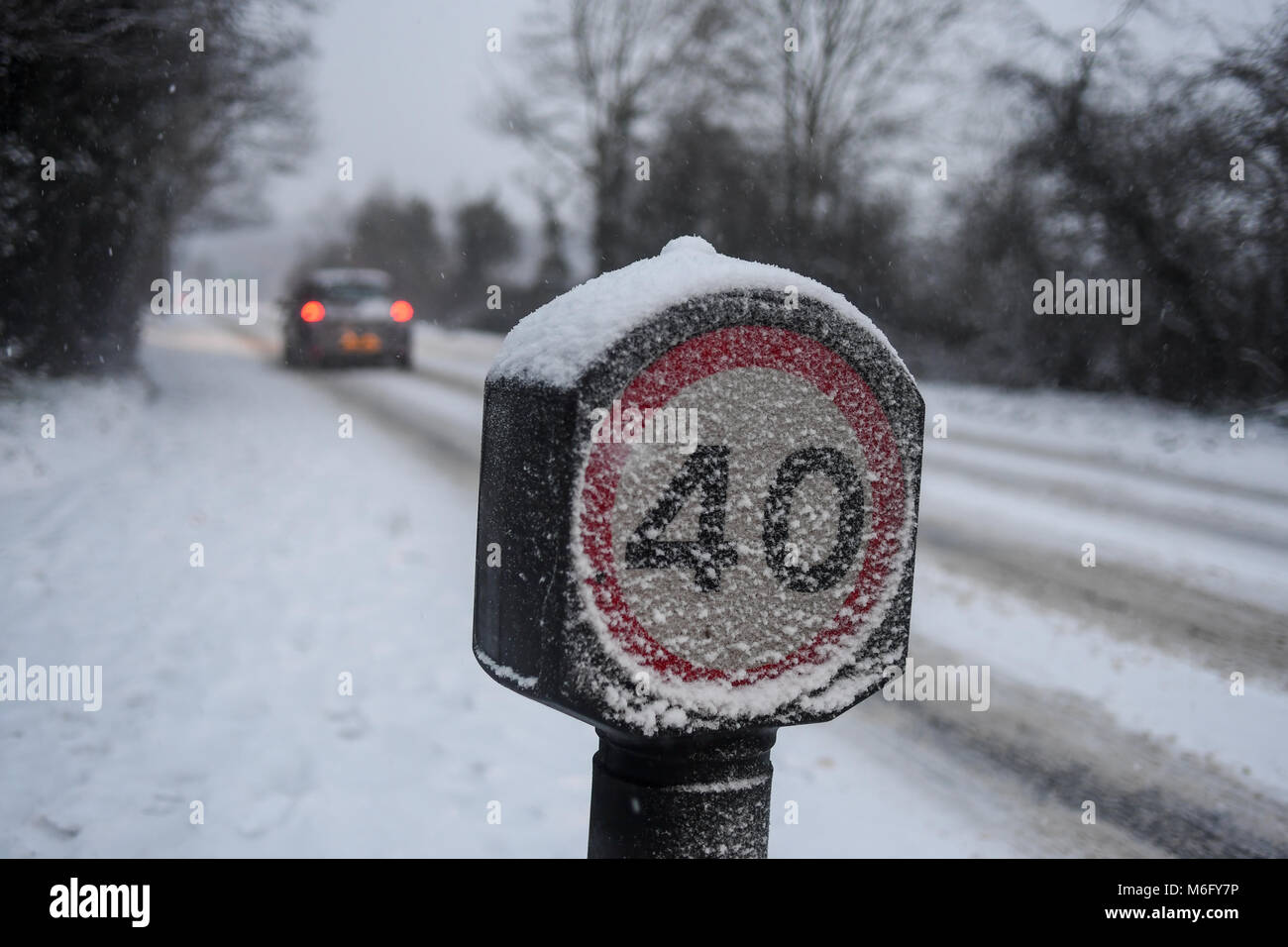 Coperta di neve 40mph segno sulla A36 verso Salisbury Inghilterra in difficili condizioni di guida nella neve di marzo 2018. Foto Stock