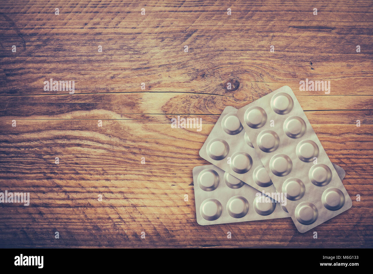 Immagine medica di un blister di farmaci su una tavola in legno rustico Foto Stock