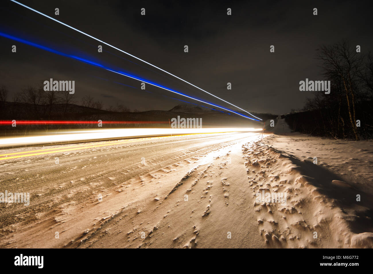 Traccia di luce auto sulla strada di neve Foto Stock