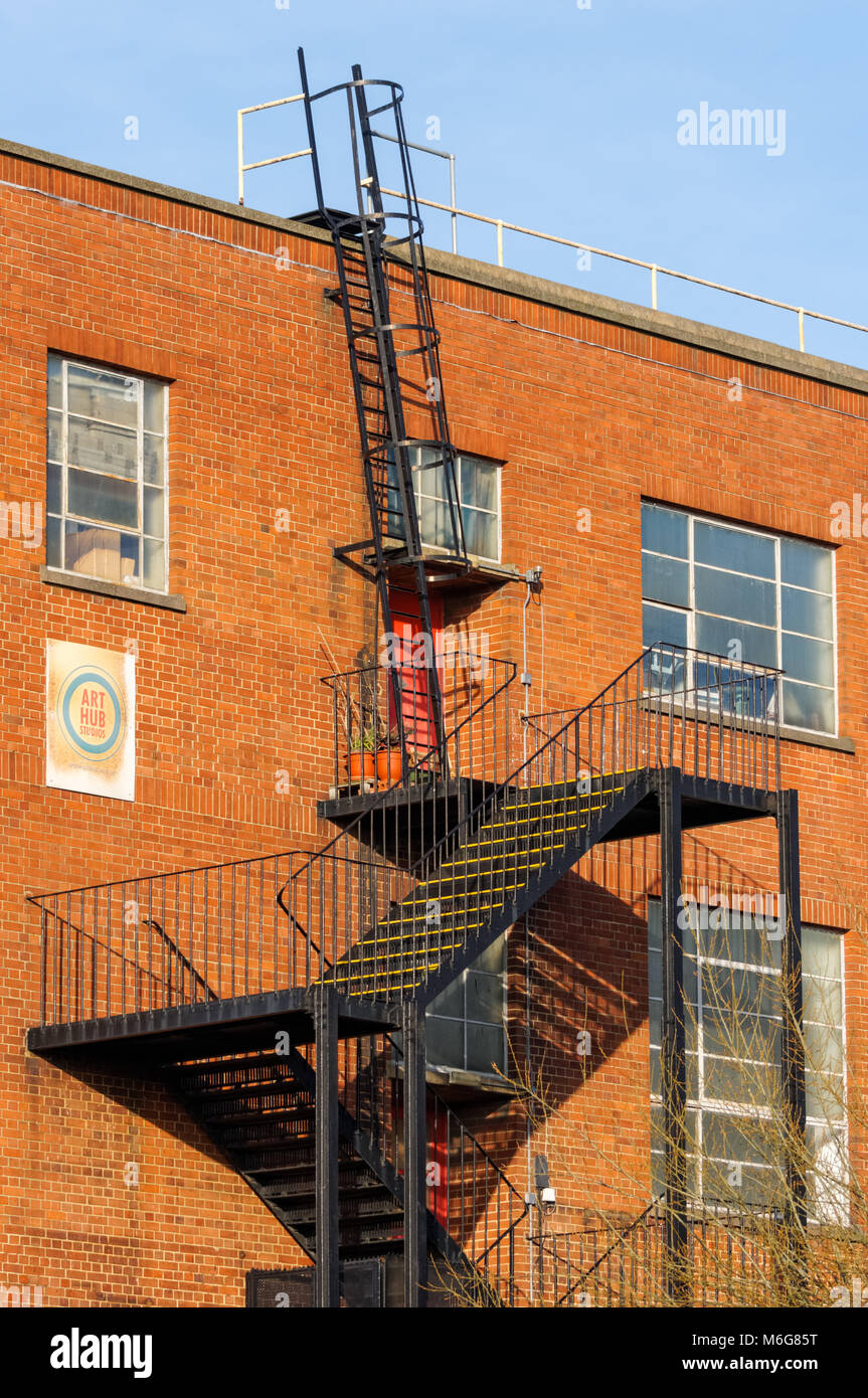 Fire escape la scala sul lato industriale di un edificio in mattoni, London, England, Regno Unito, Gran Bretagna Foto Stock
