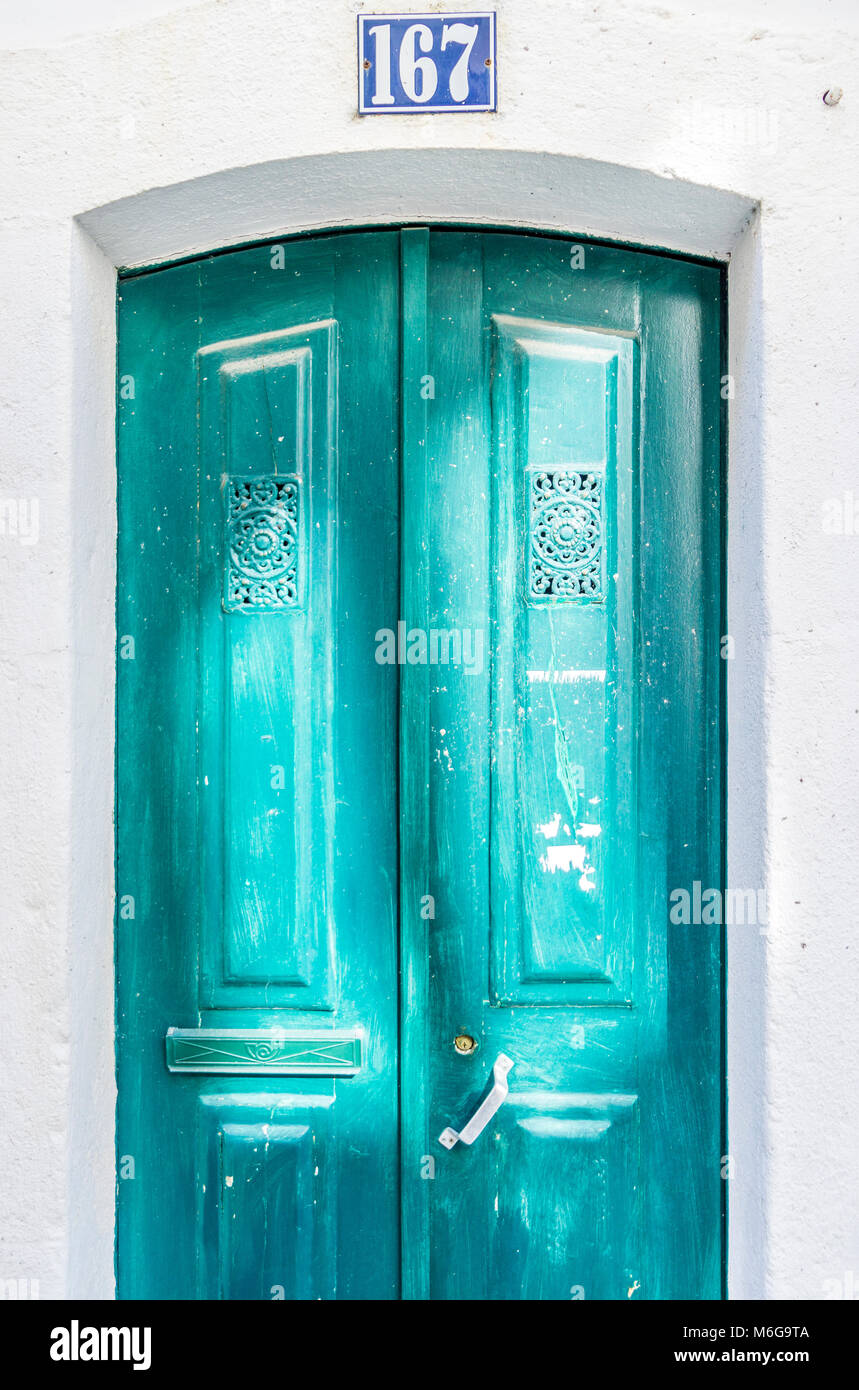Il turchese, porta di legno illuminate dal sole riflesso nella parte storica di Lisbona, Portogallo Foto Stock