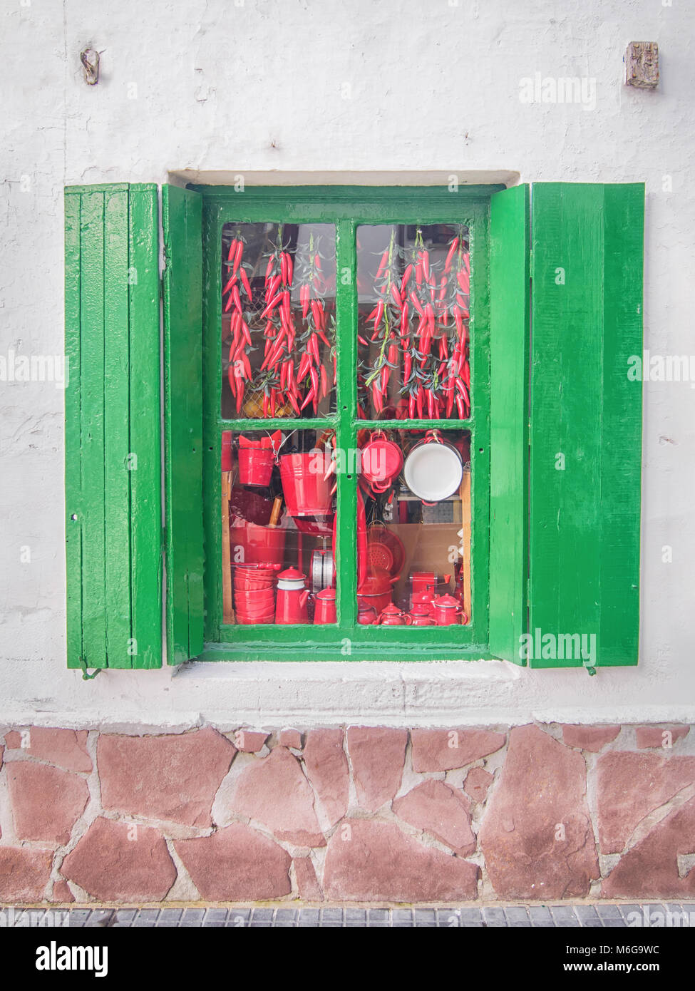 Parzializzato spagnolo vecchia finestra verde con diversi beni rosso dietro il vetro Foto Stock