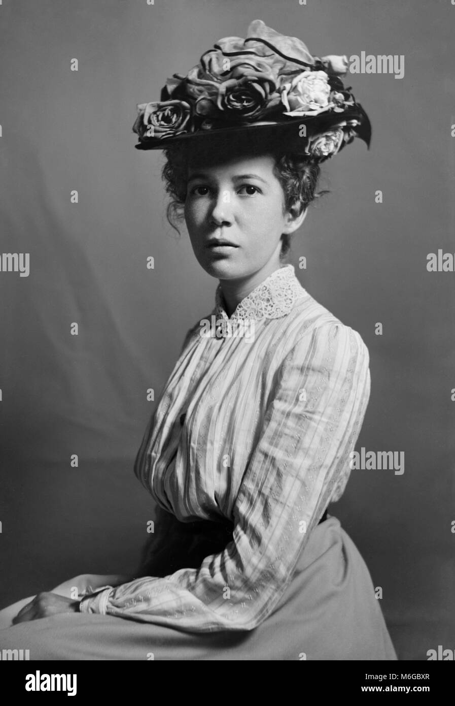 Giovane e bella donna che indossa un cappello alla moda pone, ca. 1900. Foto Stock