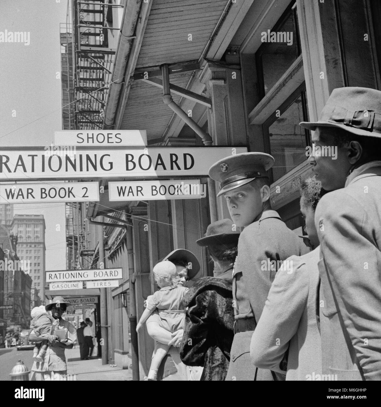 New Orleans, Louisiana, marzo 1943. Linea alla scheda di razionamento durante la Seconda Guerra Mondiale. La posizione è il blocco 500 di Gravier Street. Nota parte della Hibernia Bank Building visibile in distanza a sinistra. Foto Stock