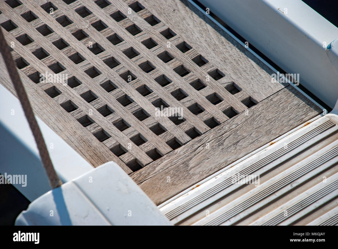 Primo piano del ponte degli yacht con griglia in legno teak, che mostra la maestria artigianale Foto Stock