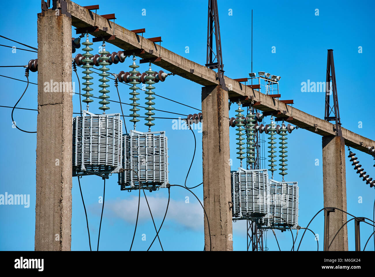 Barriera ad alta frequenza sulla gabbia rotonda del cavo della linea di alimentazione contro il cielo blu. Fornitura di energia agli impianti metallurgici Foto Stock