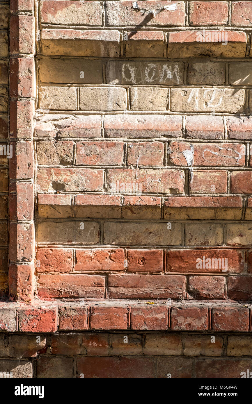 Il muro di mattoni rossi dell'edificio vintage si avvicina come sfondo. Edificio storico Foto Stock