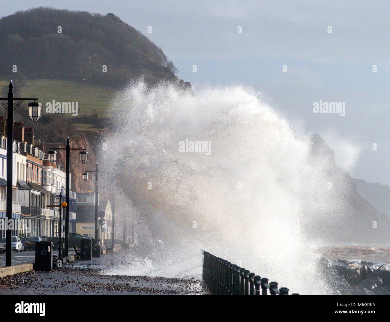 Sidmouth, Devon, 4th Mar 18 non ancora finito - Storm Emma libra in Sidmouth, con onde che torreggiano sopra le case e gli hotel sul lungomare. Un brusco aumento delle temperature, combinato con un annerimento dall'acqua di mare, ha rimosso ogni traccia della neve che copriva l'Esplanade il giovedì e il venerdì. Foto Stock