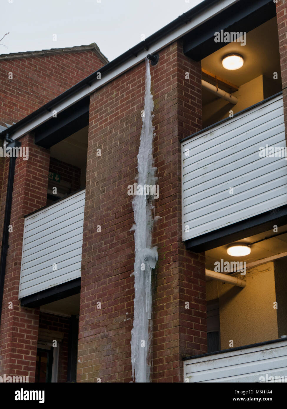 Regno Unito Meteo: gigantesca a 3 piani (oltre 20 piedi) ghiacciolo formati  formano un gas congelati caldaia tubo di scarico su un blocco di  appartamenti in centro della città mercato di Ashbourne,