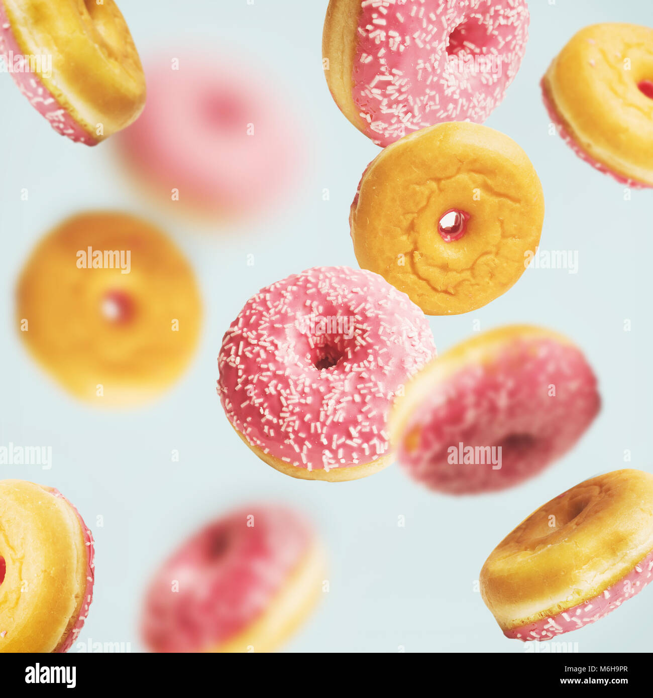 La caduta o battenti vetrate rosa ciambelle con spruzzino a pastello blu sfondo , layout creativi o di un modello Foto Stock