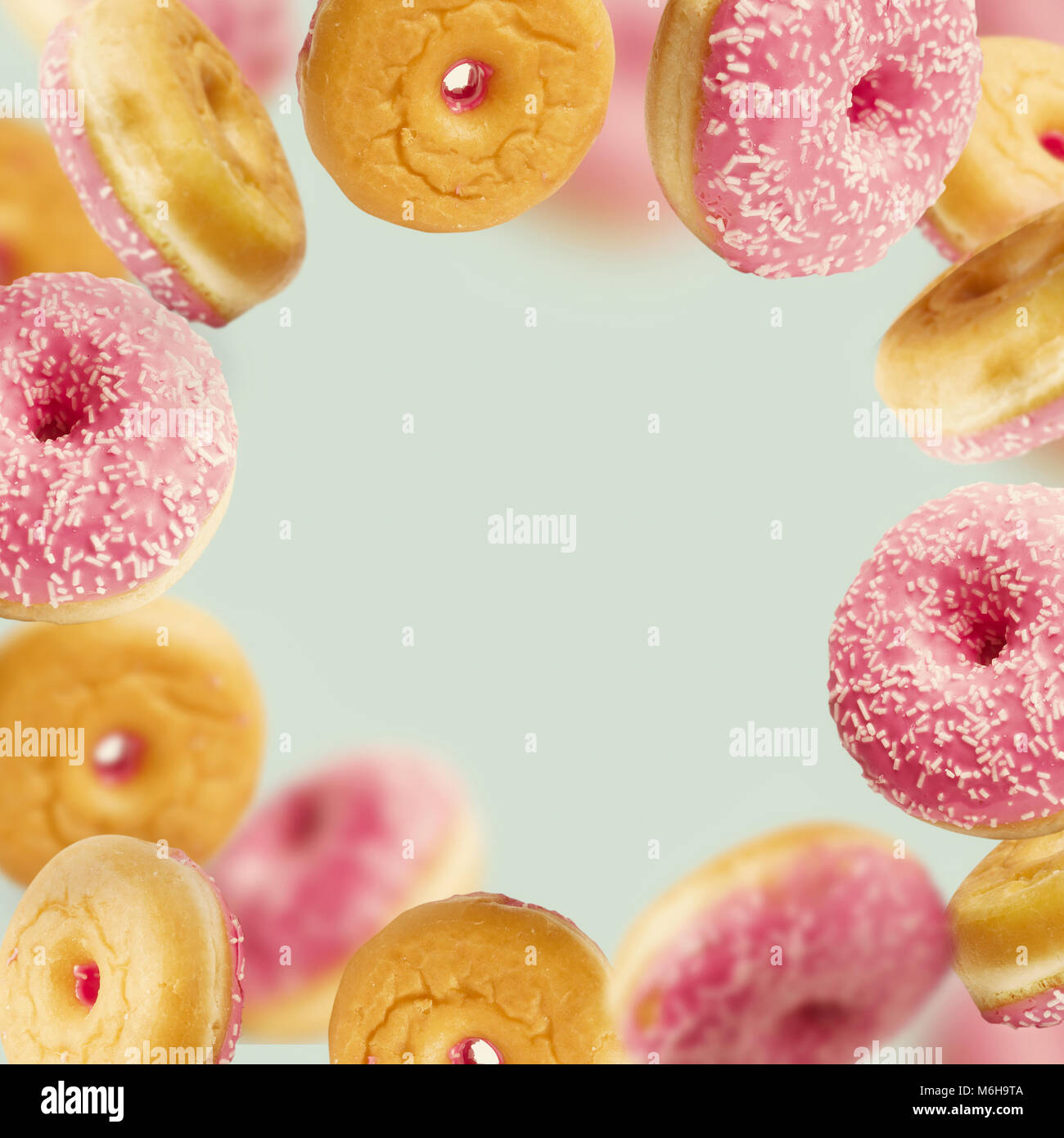 La caduta o battenti vetrate rosa ciambelle con spruzza in movimento a pastello blu sfondo , telaio Foto Stock