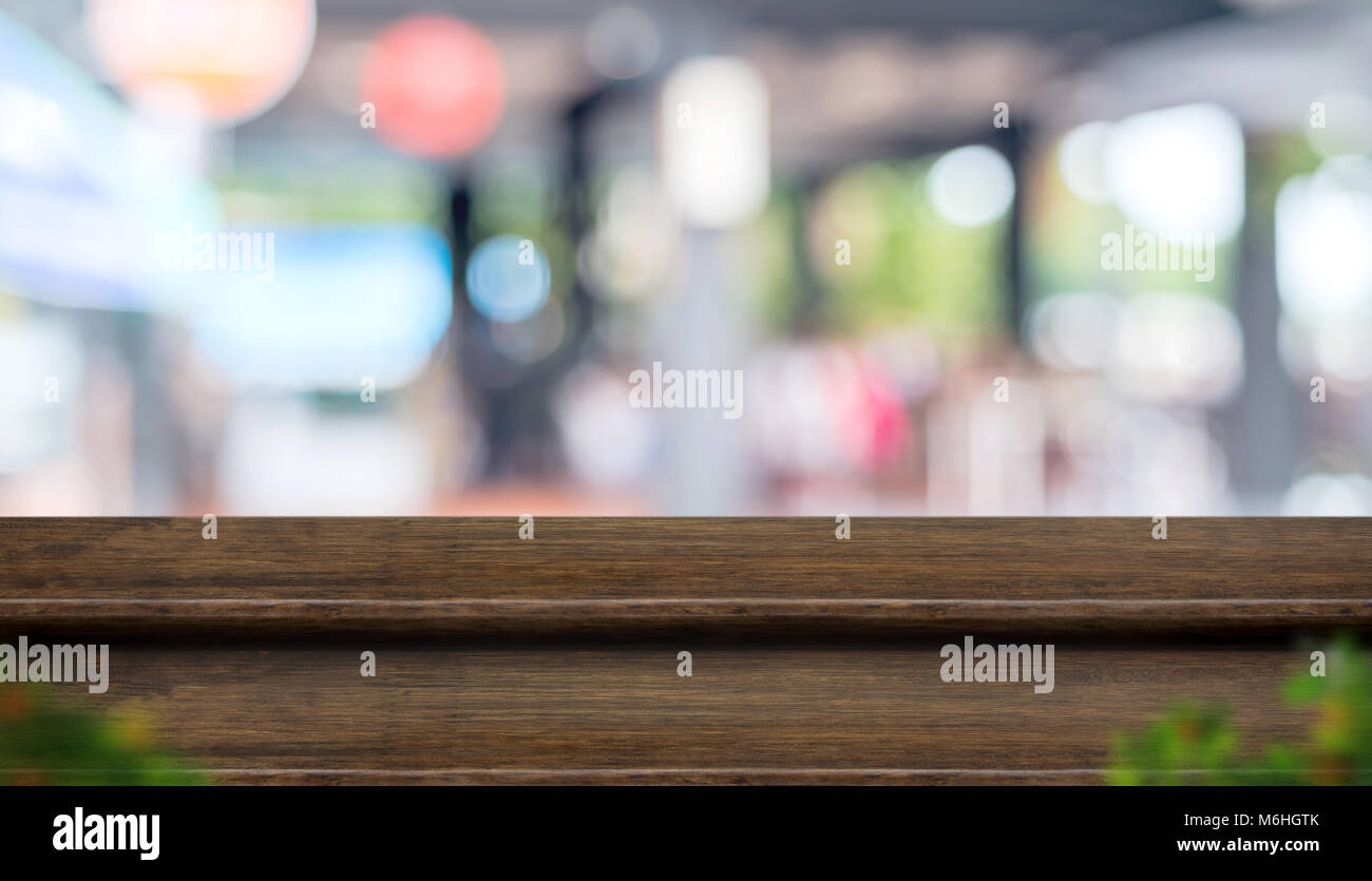 Fase di vuoto legno scuro table top stand alimentari con blur cafe ristorante sfondo bokeh luce e di foglia in primo piano,Mock up per il display del prodotto o montage Foto Stock