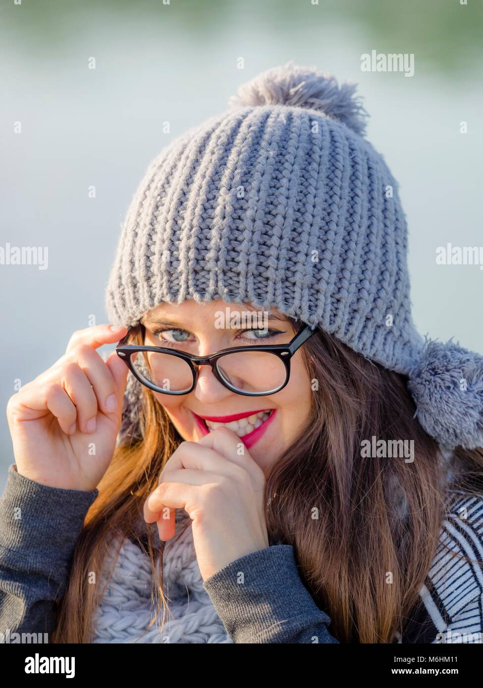 Piuttosto giovane donna ritratto con il grigio inverno cappello e occhiali Foto Stock