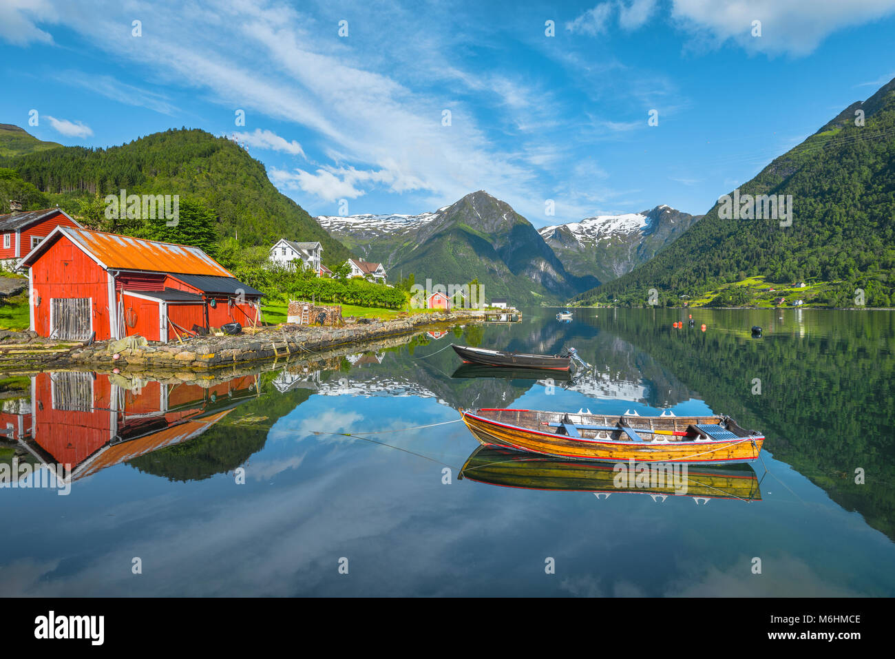 Barche e pescatori rosso capanna, Norvegia, riva del mare e la baia di Balestrand con mirroring delle montagne del ghiacciaio, Esefjorden, Sognefjorden Foto Stock
