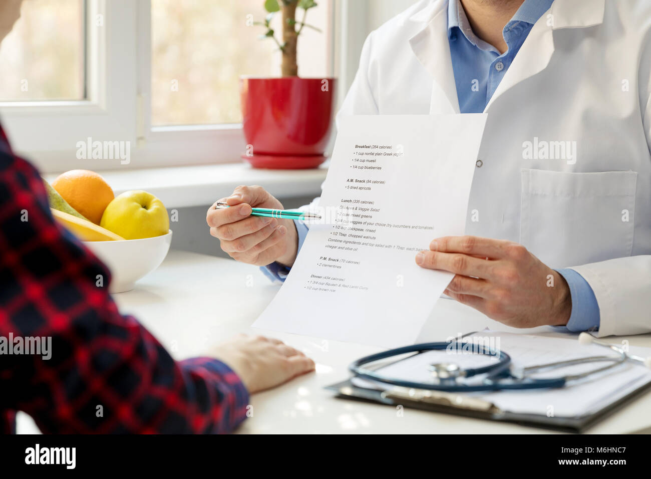 Nutrizionista e il paziente a discutere di nutrizione bilanciata in office Foto Stock