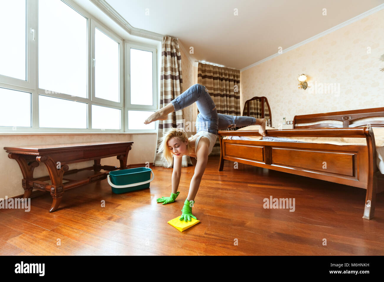 Casalinga acrobat non trucchi durante la pulizia dell'appartamento. Foto Stock