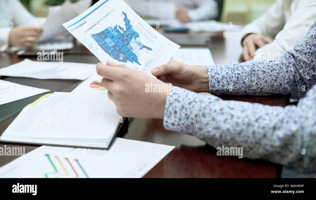 PR Manager di controllo documento report in Business meeting, statistiche regionali Foto Stock