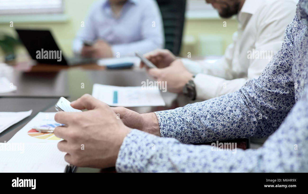 Riunione Operativa i partecipanti cercando azienda nuovo servizio online su telefoni cellulari Foto Stock
