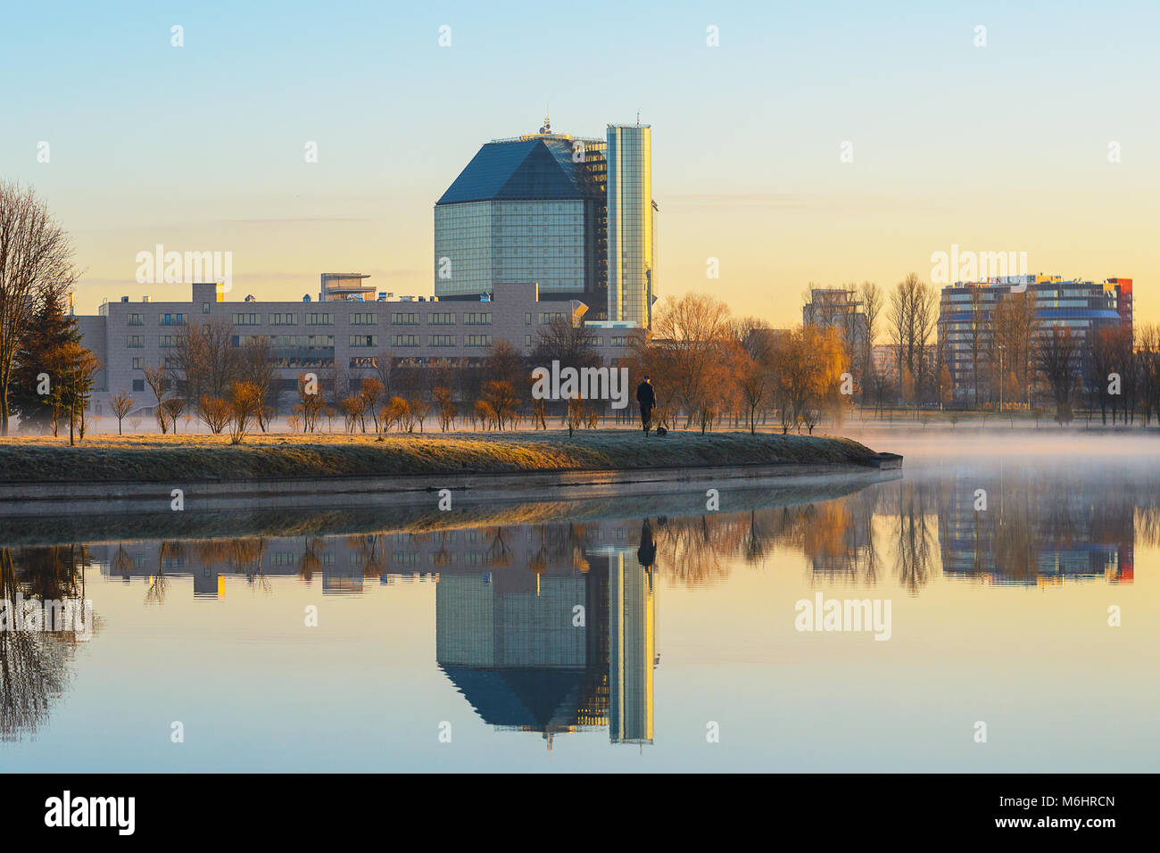 La Bielorussia Minsk - Aprile 4, 2017: il paesaggio degli scrittori' Park nella nebbia mattutina, vista la Biblioteca nazionale in tempo di mattina. Silhouette di uomo Foto Stock