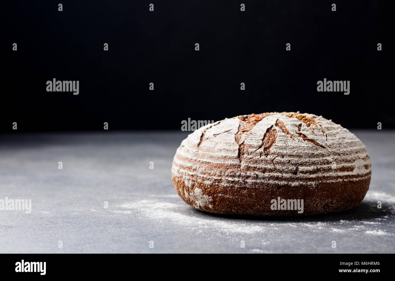 Pane di segale, grano intero su un livello di grigio ardesia sfondo. Copia dello spazio. Foto Stock