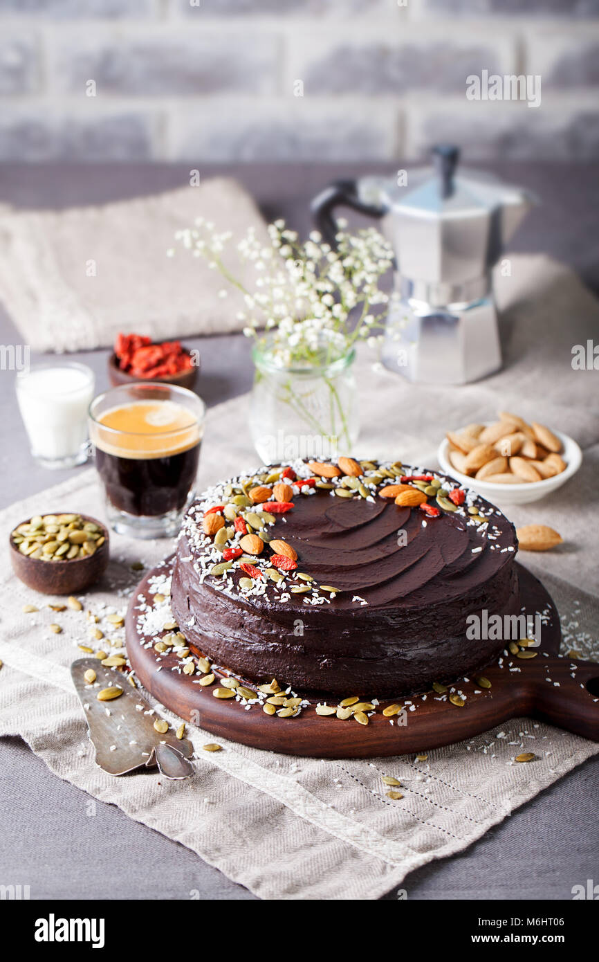 Vegano barbabietole al cioccolato torta con glassa di avocado, decorate con noci e semi. Spazio di copia Foto Stock
