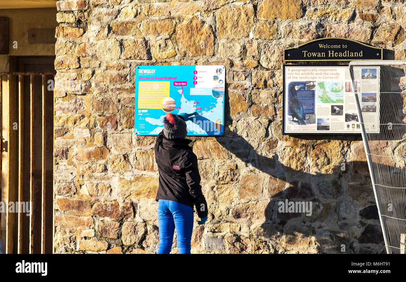 Un bambino il controllo di una mappa turistica su Towan promontorio in Newquay Cornwall. Foto Stock