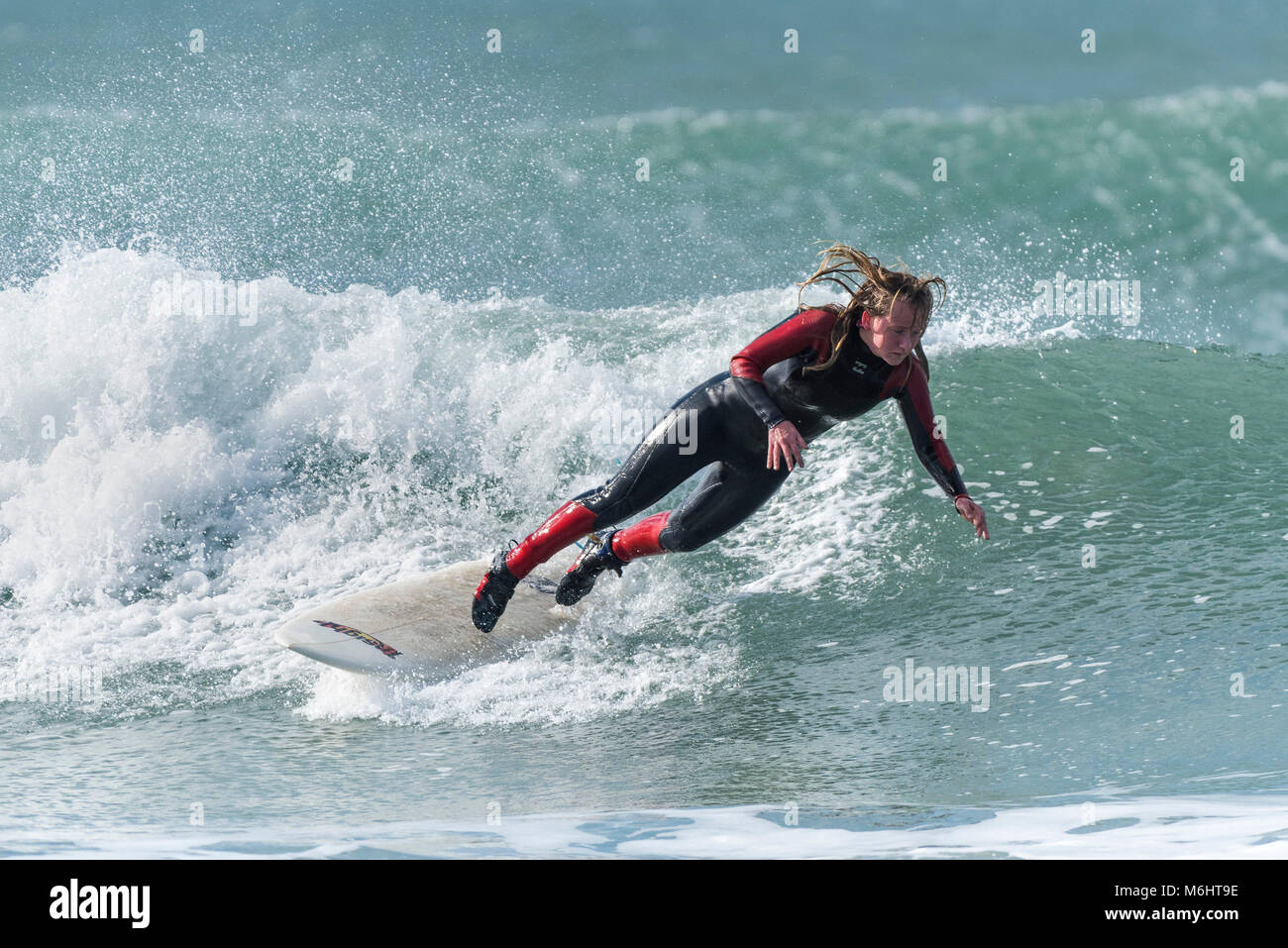 Un surfista cade fuori di una tavola da surf a basse condizioni invernali a Fistral in Newquay Cornwall. Foto Stock