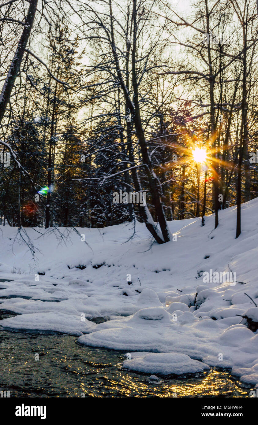 Calma Inverno Foto di un parzialmente Frozen River con un sole che splende nella fotocamera, fare bella bella e Sun Star - Sun Flare Foto Stock