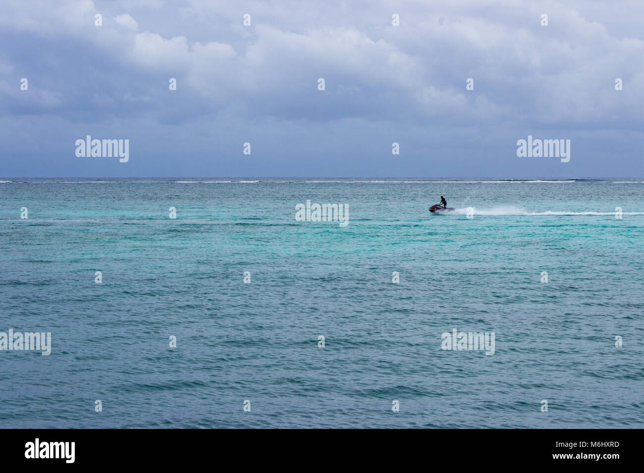 Un jet ski gare nei Caraibi all'interno della barriera corallina Meso-American. Foto Stock