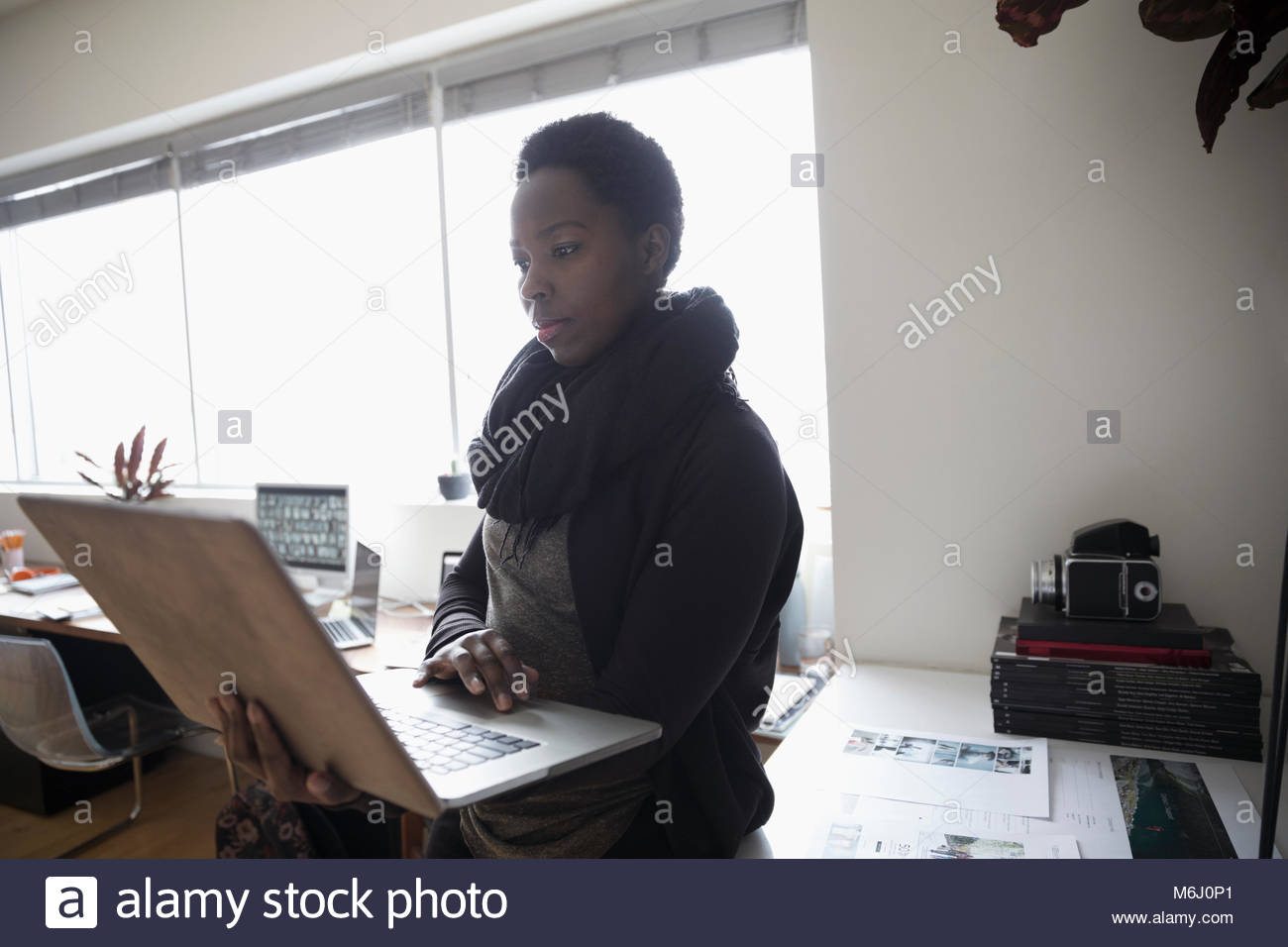 Femmina editor di foto utilizzando computer portatile in ufficio Foto Stock