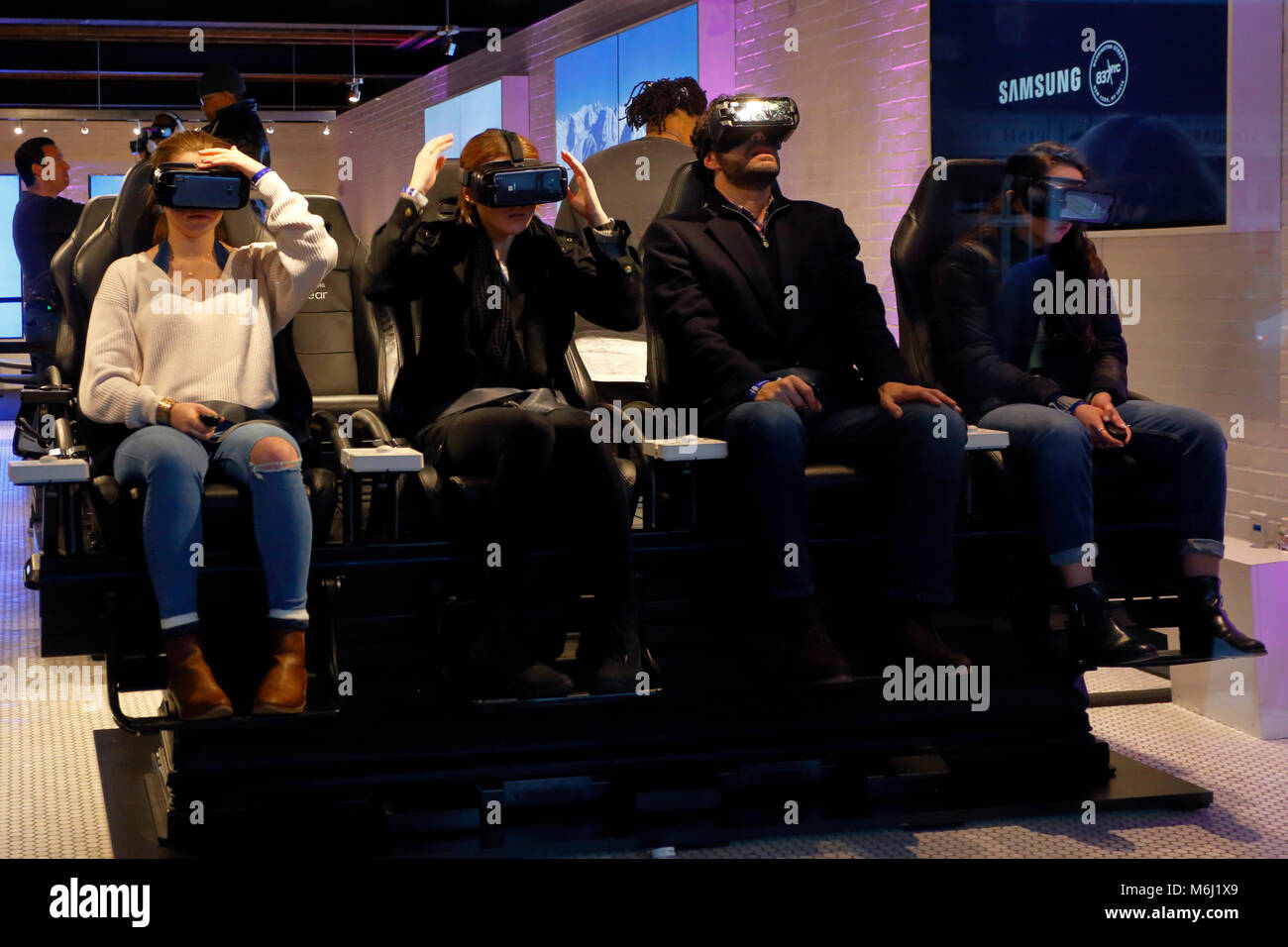 Persone che indossano occhiali per la realtà virtuale in un negozio di tecnologia; i visori per la realtà virtuale trasformano la visione di film in un'esperienza coinvolgente e personale. Foto Stock