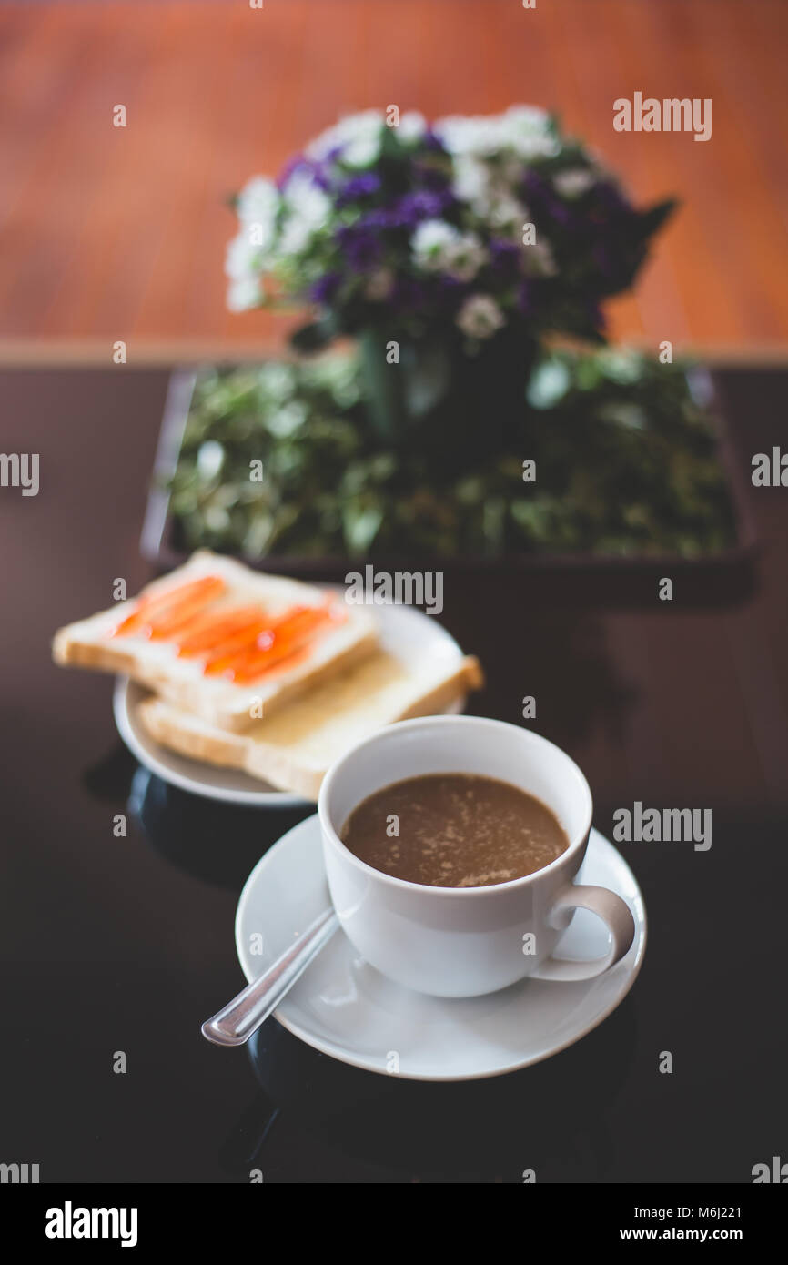 Un bianco tazza di caffè con toast sulla tavola , colore vintage Foto Stock